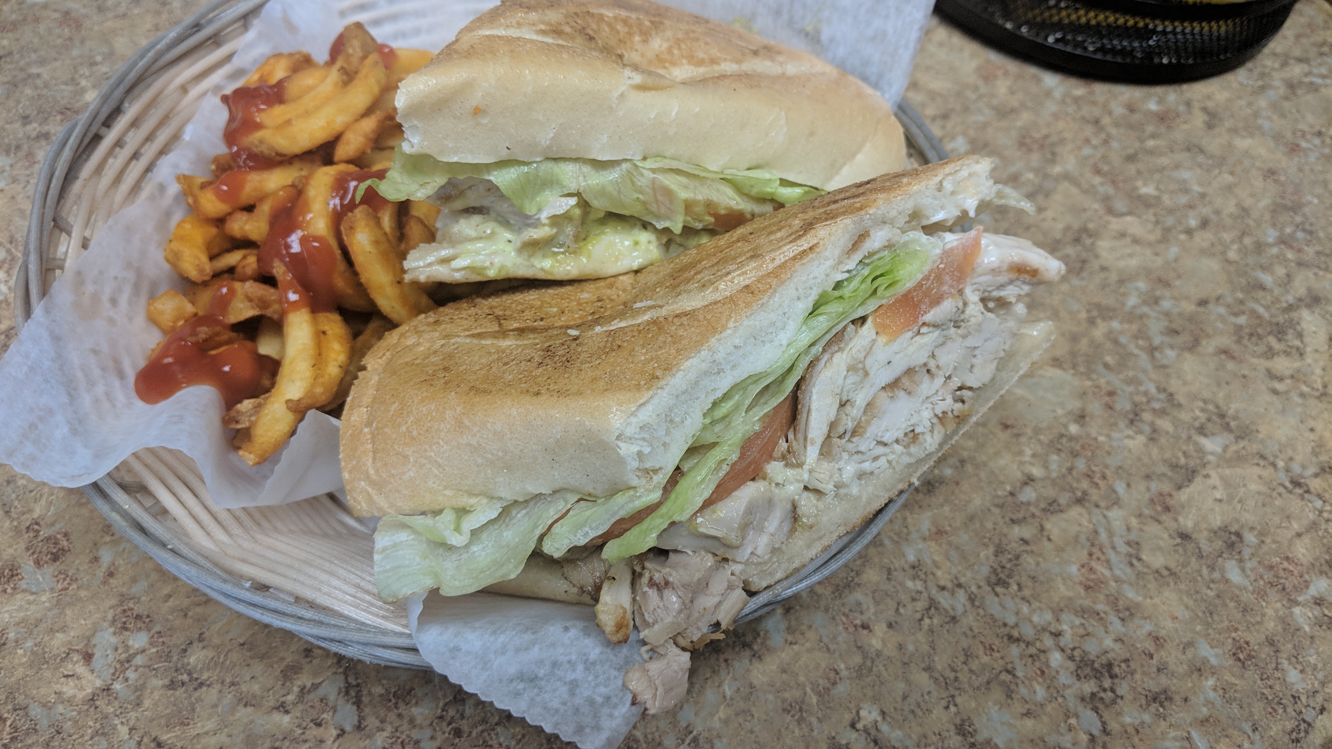 Chicken sandwich with lettuce and tomato, served with fries